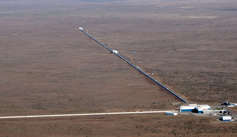 An aerial view of one of the LIGO laboratories. Two long, narrow buildings extend from a central hub.