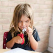 A little girl practices using scissors