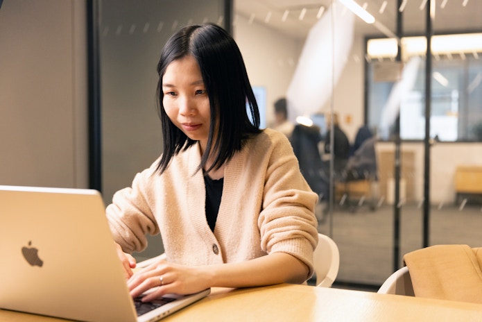 Portrait of Teresa Huang working at her laptop