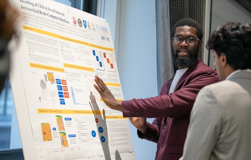 Aniaba N'Guessan presenting his poster at the SURFiN Symposium 2025.