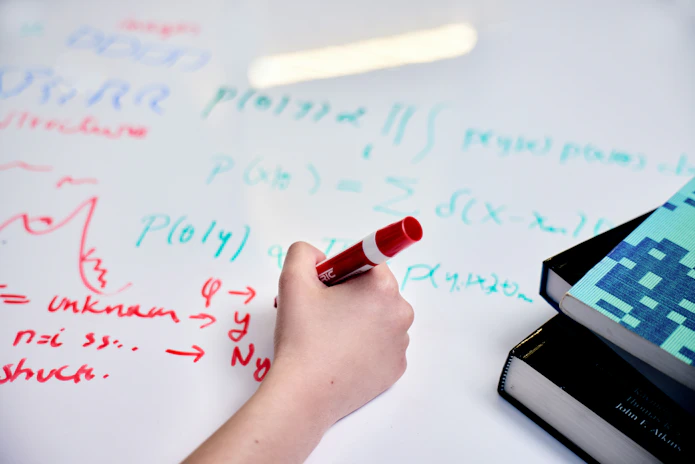 A photo of a close-up of Pilar Cossio’s handwriting on her whiteboard table with a dry-erase marker.