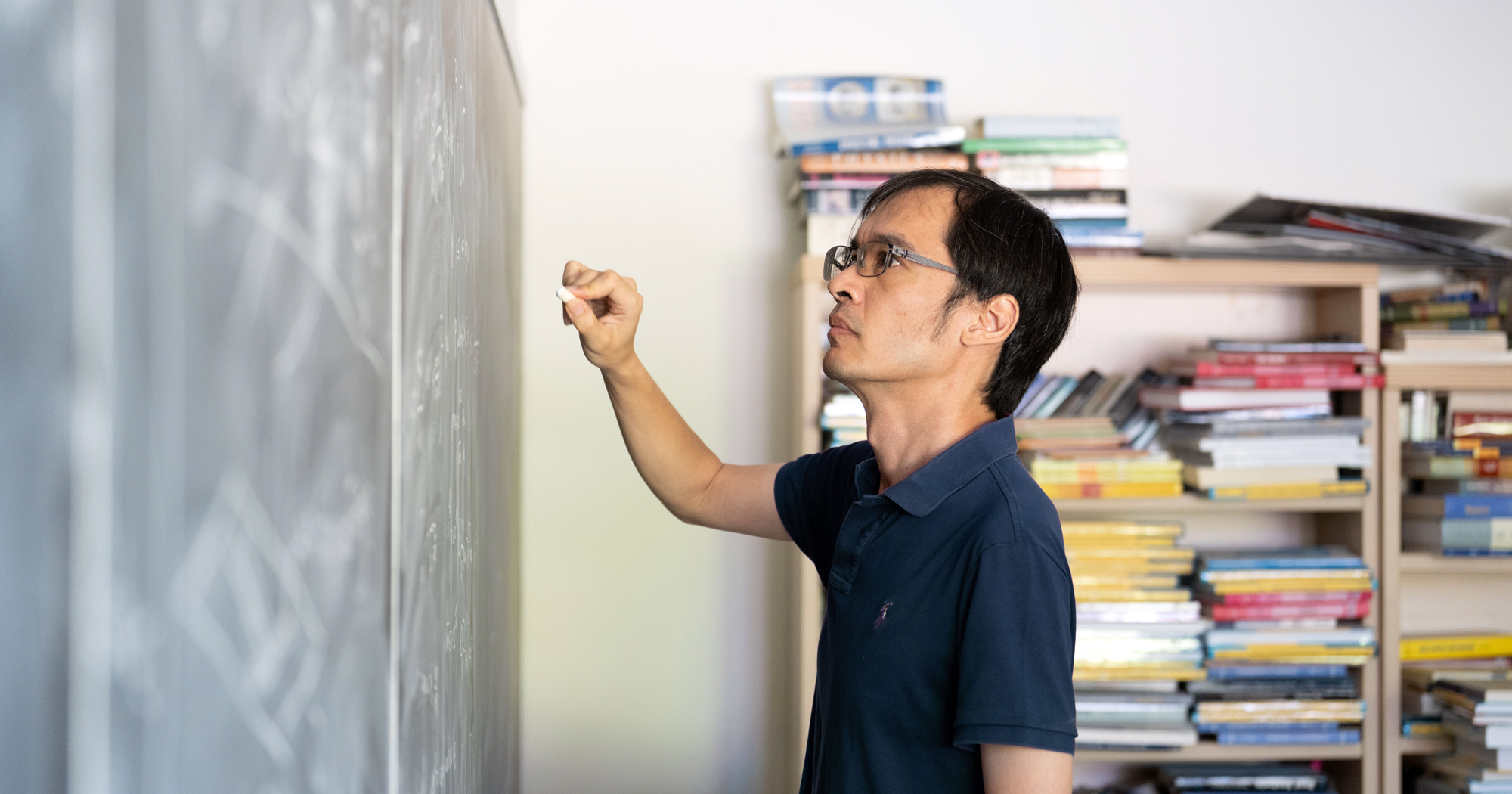 A portrait of Terry Tao near a chalkboard, taken at UCLA.