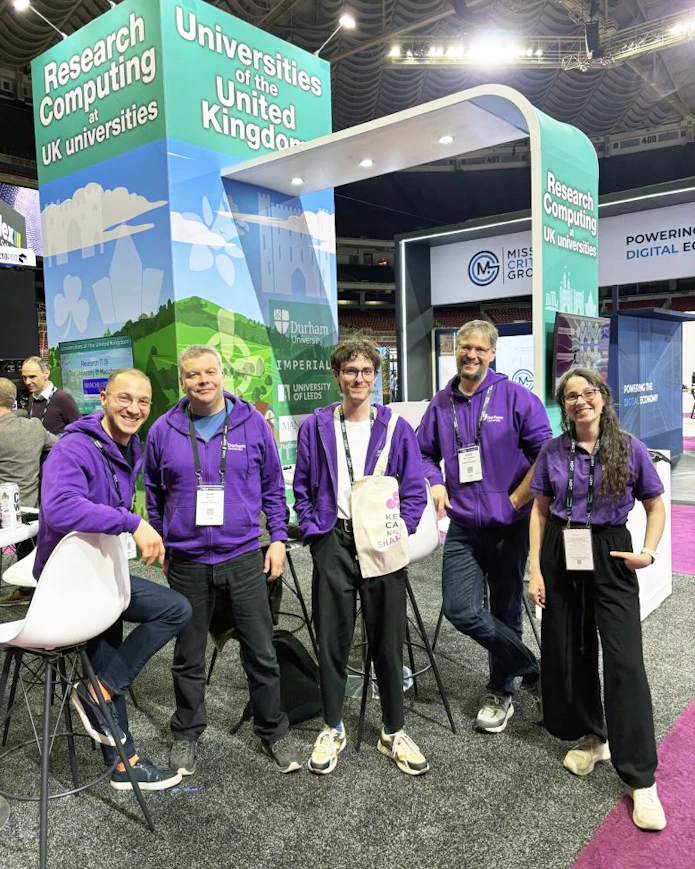 A photo of Gokberk Kabacaoglu with colleagues at a conference booth.