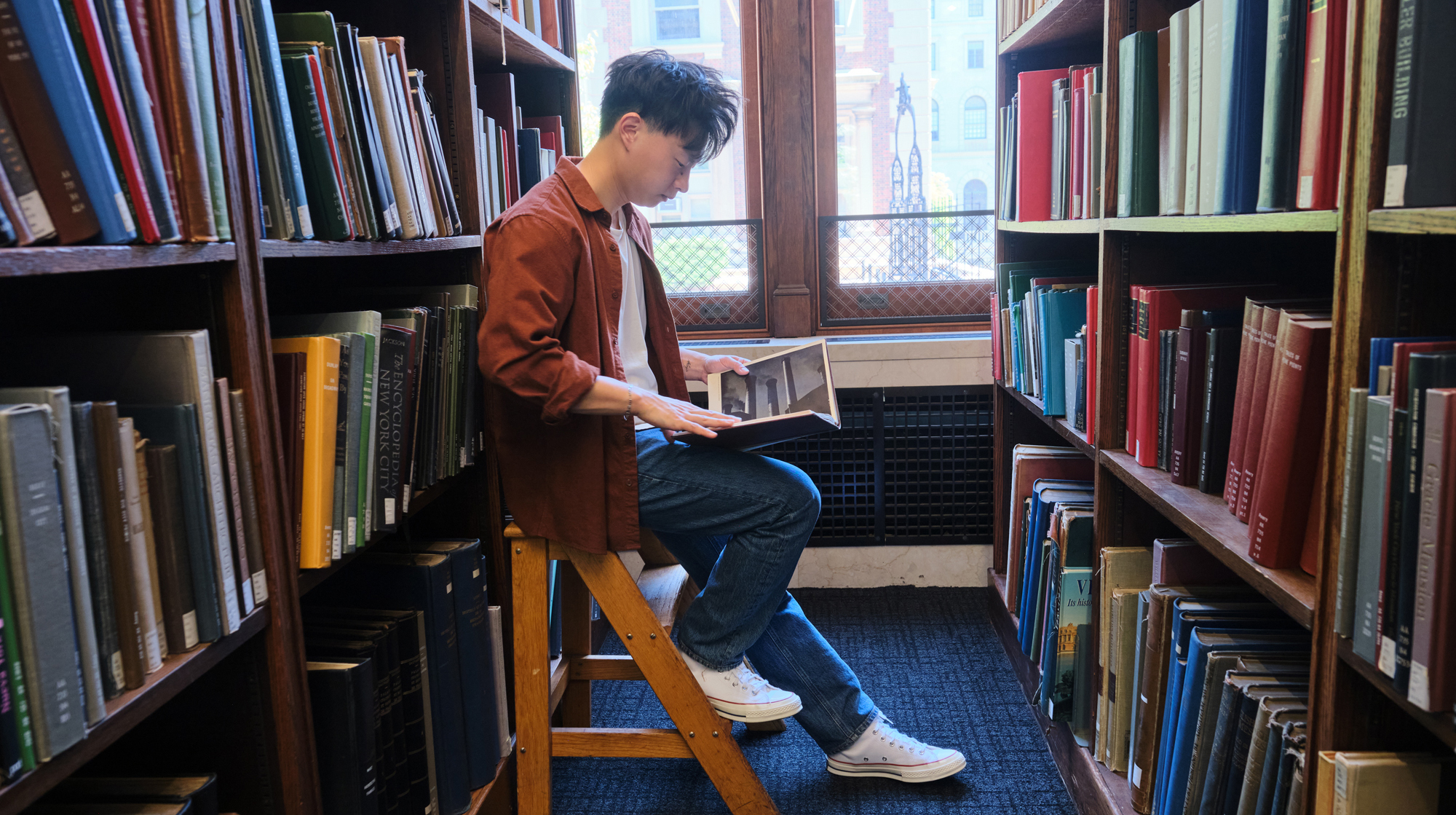 Photo of Kevin Hu sitting in the library at Columbia University