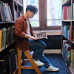 Photo of Kevin Hu sitting in the library at Columbia University