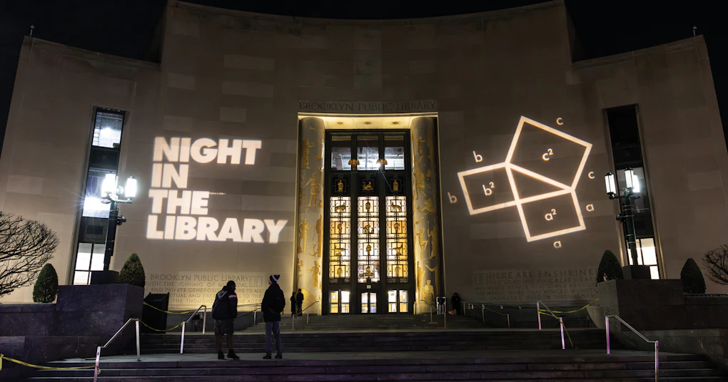 Photo of the entrance to the Brooklyn Public Library at night time.
