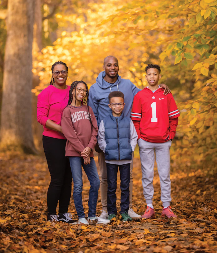 Photo of five people with trees behind them.