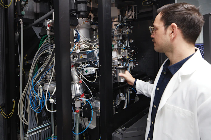 A researcher looking into a cryo-electron microscope.
