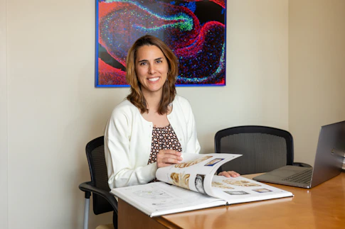 Sofia Landi sitting at a desk reading a neuroscience book.