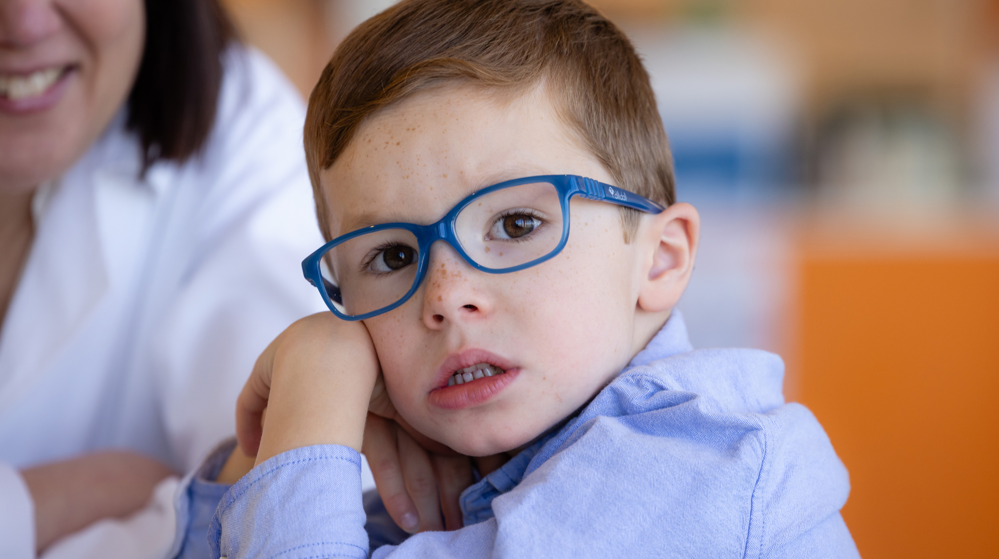 Photo of a little boy sitting with Wendy Chung.