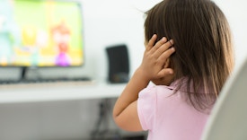 A child watching tv holding her ears because she is afraid of the sound; Child behavior theme