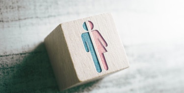 Gender Icons For Male And Female Cut In Half On Wooden Block On A Table