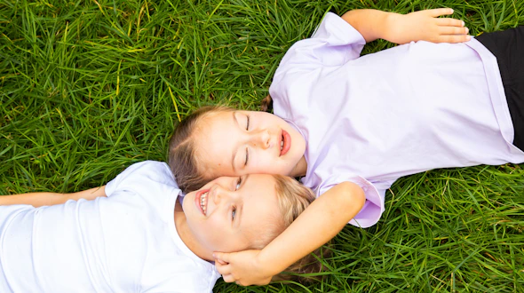 A photo of a boy and girl child lying in the grass.