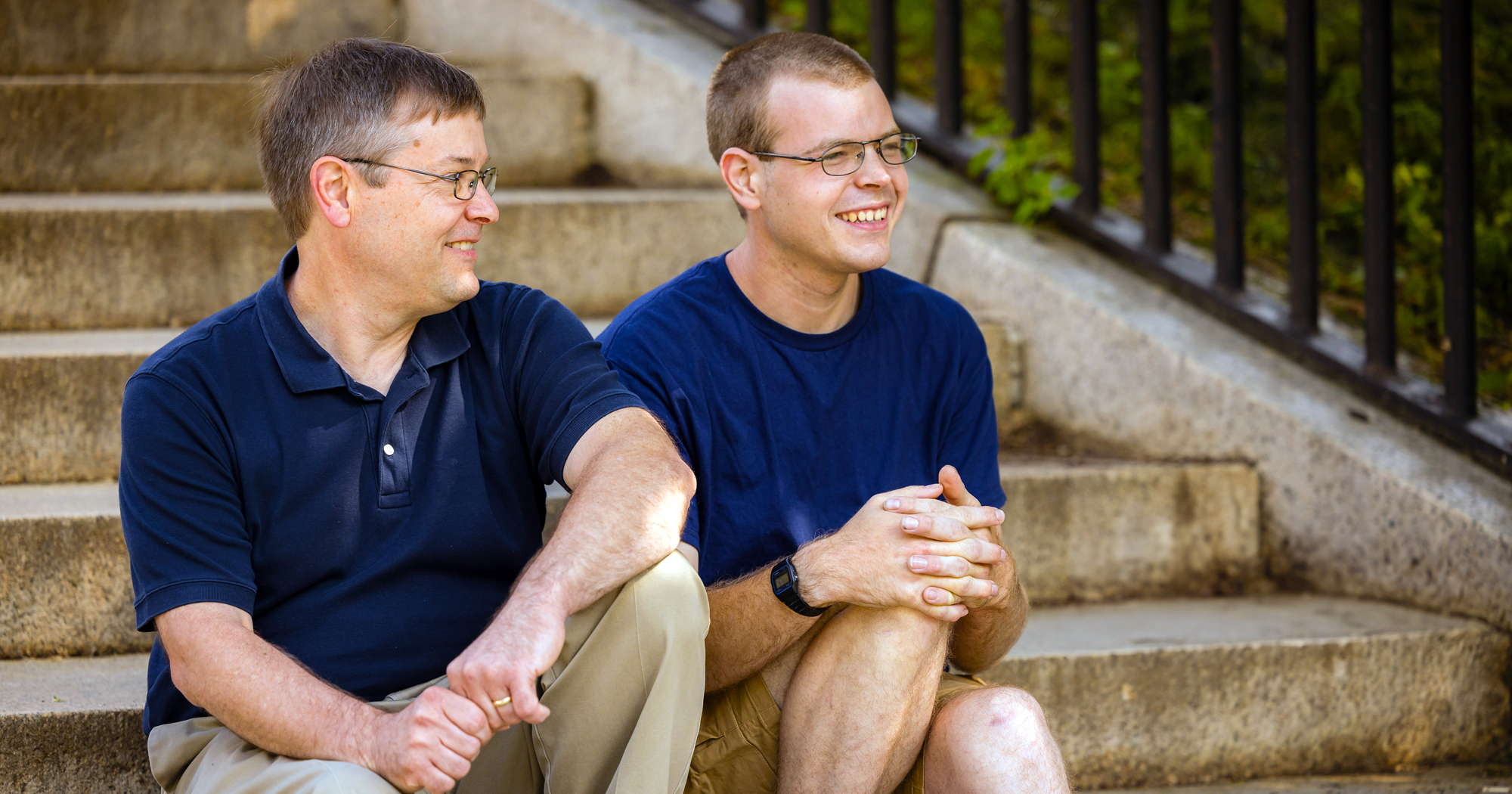 A photo of a father and son sitting on steps.